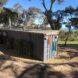black corrugated metal tiny home facing hilly landscape