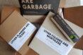 cardboard binder, planner, folders and a metal pencil tin in cardboard shipping box