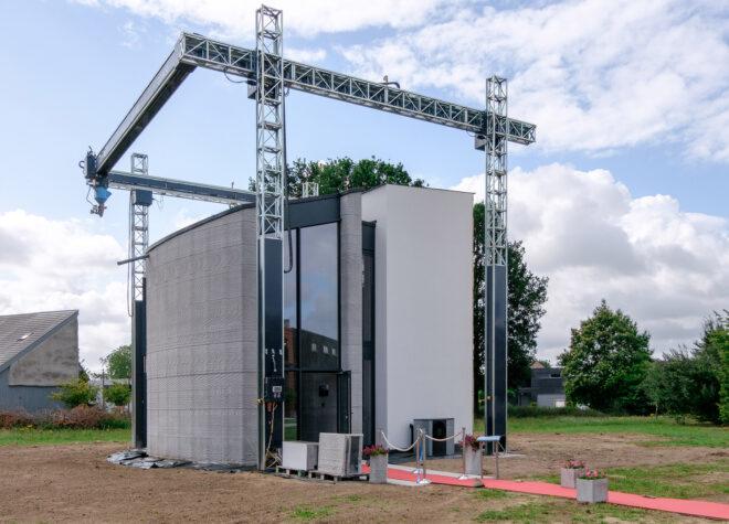 A 3D-printing construction rig, with a concrete structure underneath it.