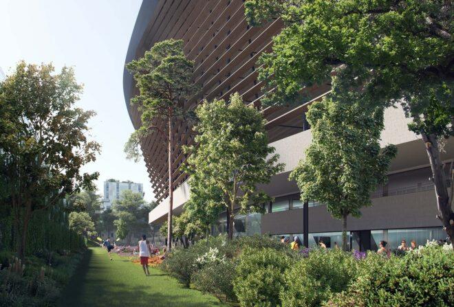 greenery surrounding a timber structure with a curved roof. people play soccer on the green lawn.