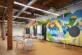 colorful wall mural on room with tables and chairs
