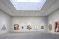 A white gallery space where a Star of David-shaped artwork sits as the centerpiece on a wall of artworks.