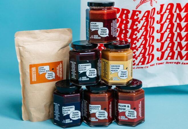 A bag of pancake mix next to a stacked pyramid of jams.