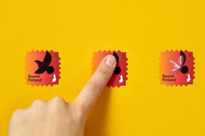 three red stamps against a yellow background. from left to right, the stamps show a bird, then a person pressing their finger to the stamp, and finally the stamp showing the bird's skeleton.