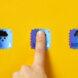 three blue stamps against a yellow background. from left to right, the stamps show a snow cloud, then a person pressing their finger to the stamp, and finally the stamp showing a thunderstorm.