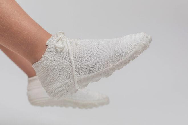 kid wearing white knitted shoes