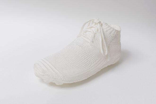 one white knitted shoe on white background