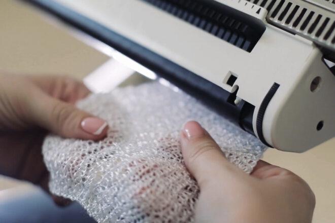 person knitting fabric swatch