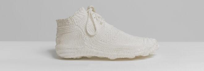 side view of white knit sneaker on white background