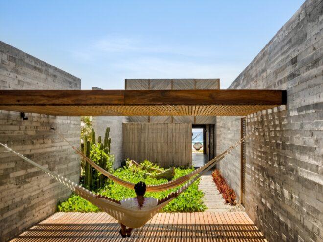 A person sitting in a hammock and looking at a small tropical garden.