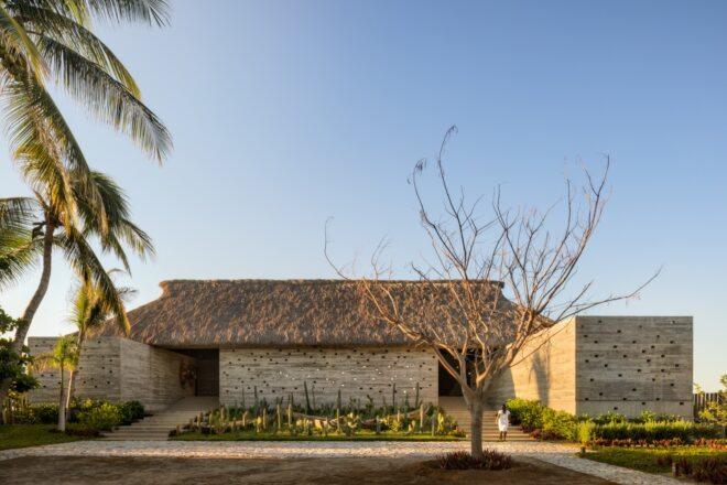 A home with two entrances, one on the left and one on the right. The roof is made of dried palm leaves.