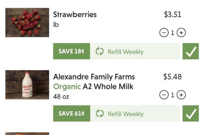 A digital grocery ordering interface, showing a cart with strawberries and milk.