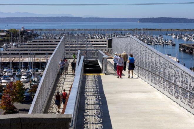 people walking on ramps leading up to a bridge
