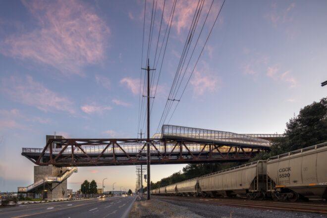 weathered steel and aluminum bridge silhouette against sunset