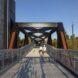 people walking on aluminum and weathered steel bridge