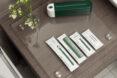 green hotel toiletries on glass platter in a hotel bathroom