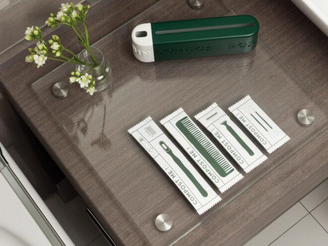 green hotel toiletries on glass platter in a hotel bathroom