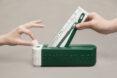person putting toothbrush in waste box