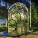 curved clear greenhouse lit up at night