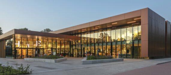 L-shaped building with glass walls at dusk