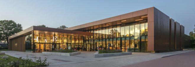 L-shaped building with glass walls at dusk