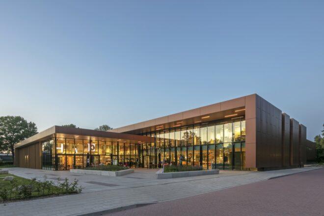 L-shaped building with glass walls at dusk