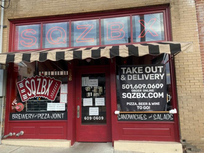 red restaurant storefront with black-and-white striped awning