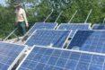 Zac Smith standing near solar panels
