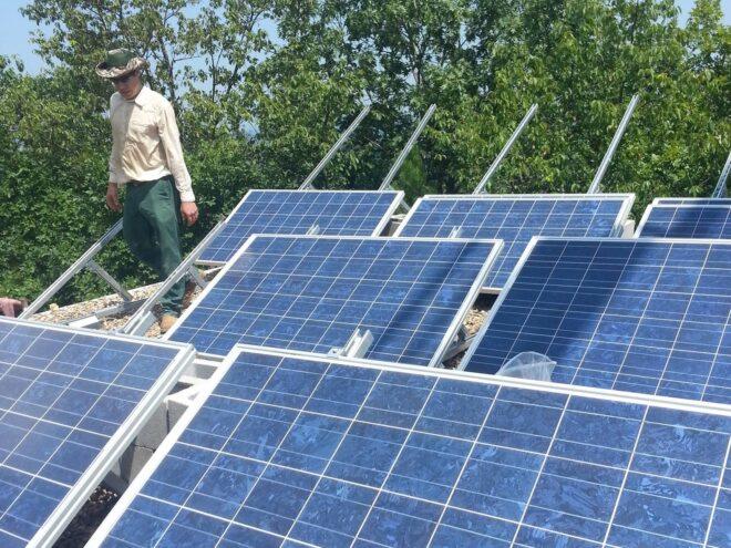 Zac Smith standing near solar panels