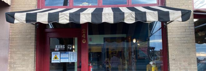 red radio station storefront with black-and-white striped awning