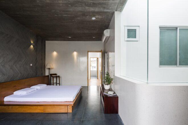 large white bed on wood bedframe in room with gray walls and ceilings