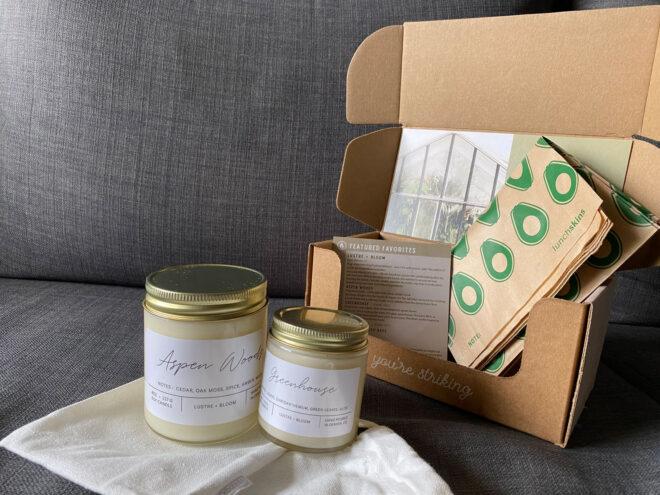 two candles and paper sandwich bags inside a cardboard box