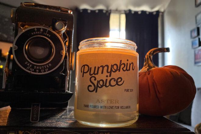 pumpkin spice candle near camera and pumpkin