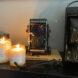 two candles near old cameras on fireplace mantel