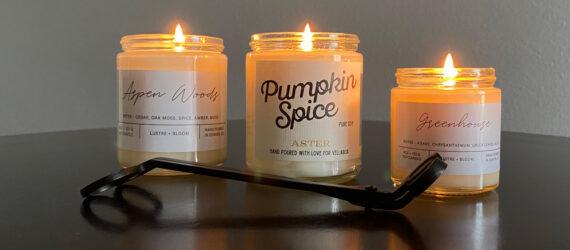 three lit candles and wick trimmer on glossy table