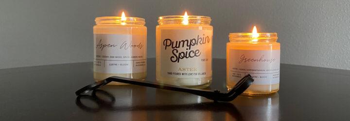 three lit candles and wick trimmer on glossy table