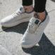 person on sidewalk wearing beige sneakers