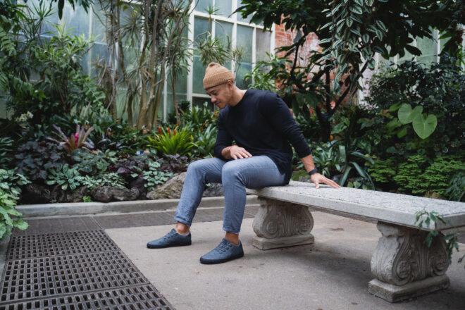 person in greenhouse wearing dark gray sneakers