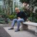 person in greenhouse wearing dark gray sneakers