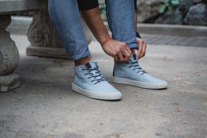 person lacing up light blue sneakers