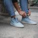 person lacing up light blue sneakers