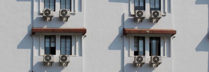 air conditioners on windows of white building