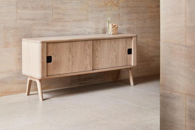 light wood credenza against tan wall