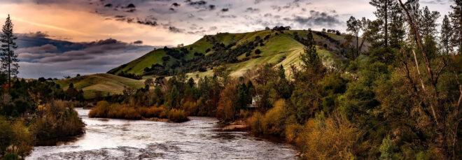 river running through forest and mountains in California at sunset