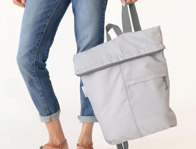 person holding gray backpack