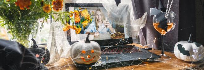 person video-chatting with someone with pumpkins and flowers on table