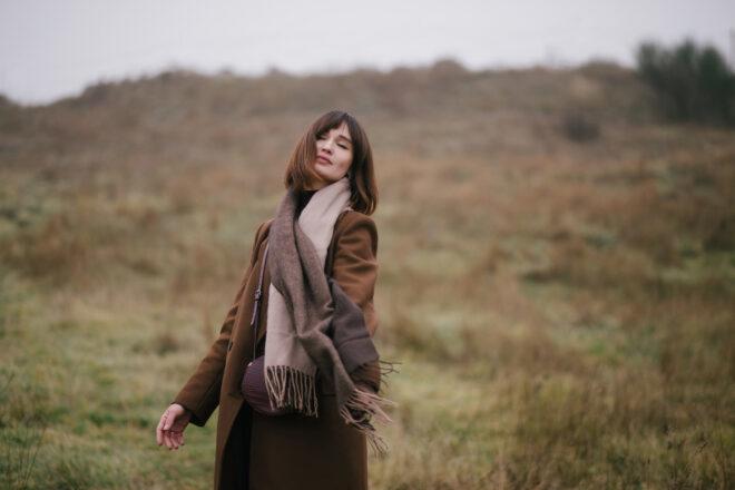 person wearing cashmere scarf and brown coat