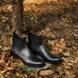 black chelsea boots on pile of fallen leaves
