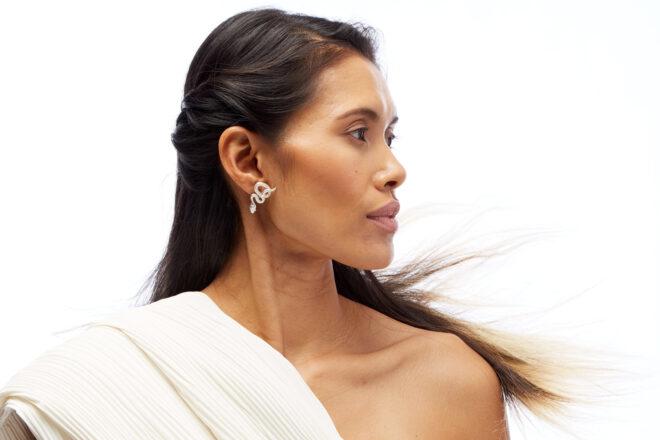 person wearing silver snake earrings