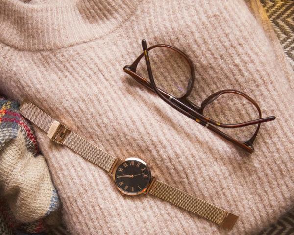 pink sweater, brown glasses, gold watch, brown boots and plaid scarf flat lay